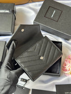 Dark small bag with snap button and textured leather face, open display