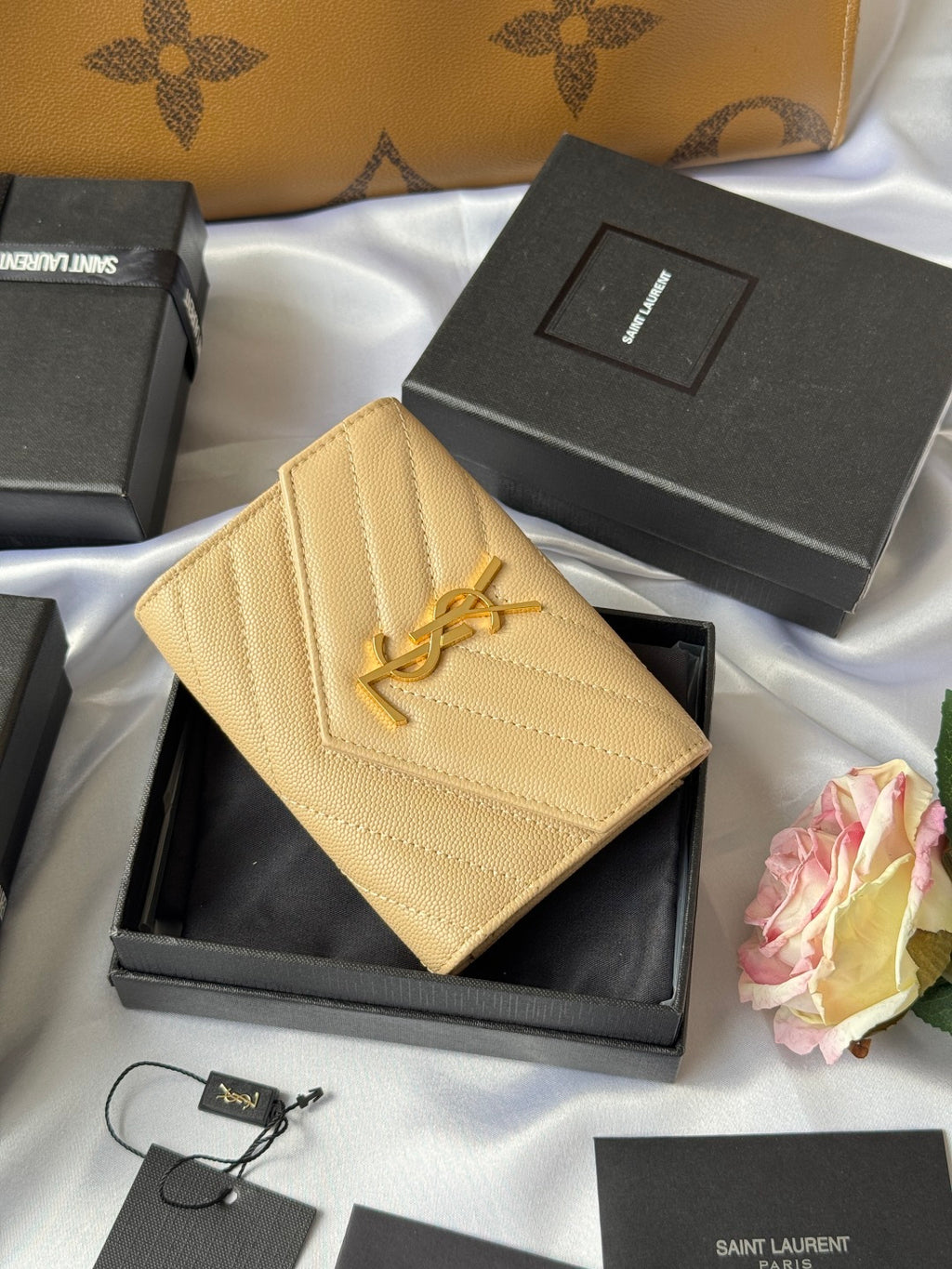 Small bag wallet in light yellow textured leather with YSL logo, angled view
