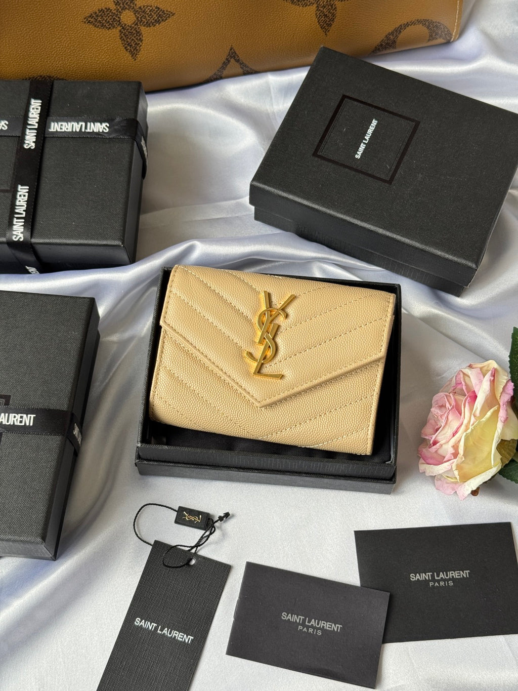 Small bag wallet in light yellow textured leather with YSL logo, shown on box