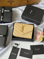 Small bag wallet in light yellow textured leather with YSL logo, shown on box
