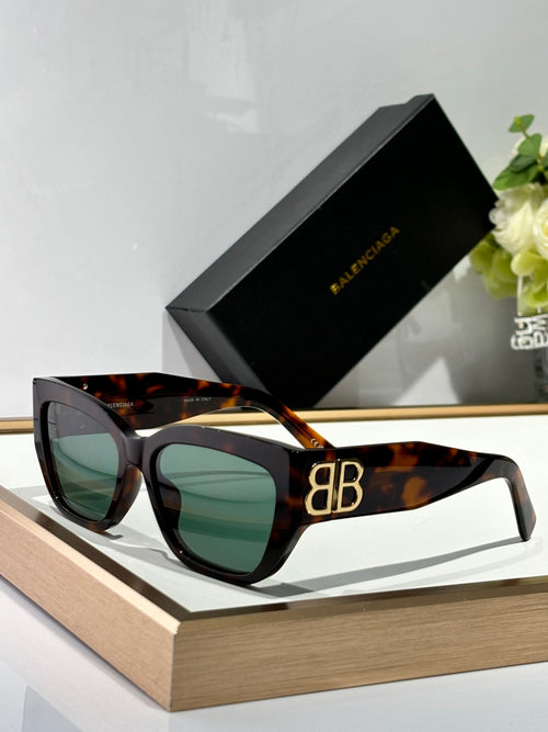 Balenciaga sunglasses with tortoiseshell frames, green-tinted lenses, and gold B B logo.