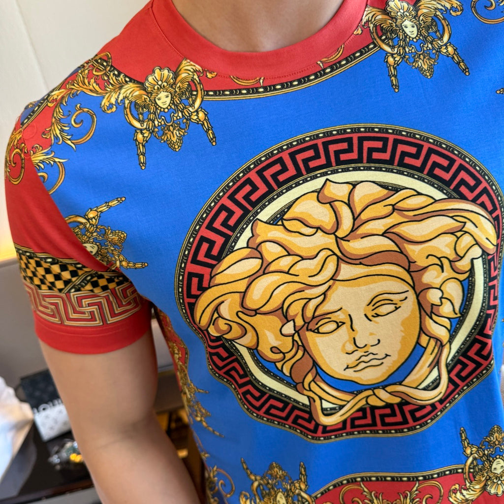 Versace T-shirt close-up with blue fabric, red trim, and gold face medallion