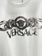 Versace white crewneck T-shirt close-up of metallic lion crest and Versace text