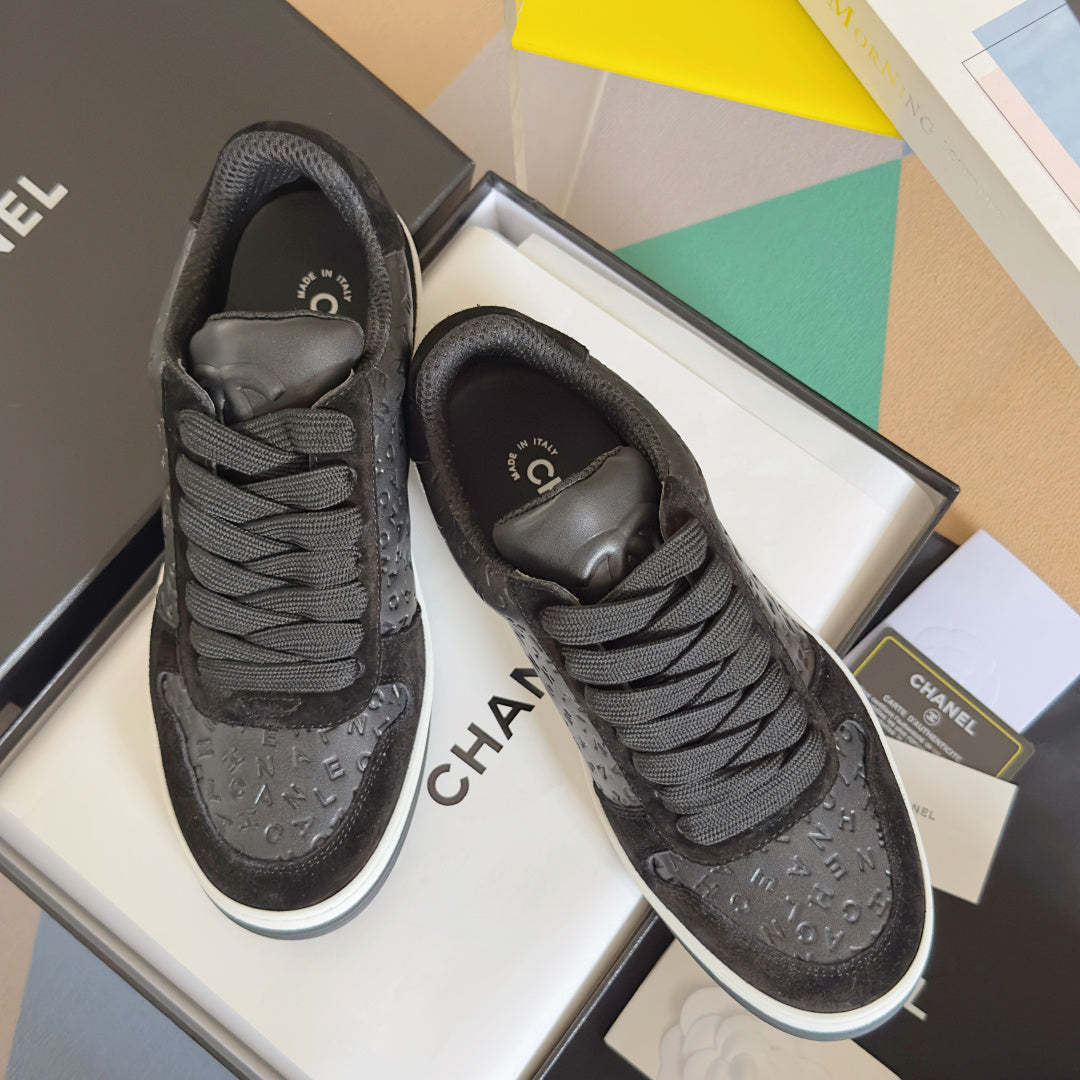 Black Chanel lace-up sneakers with textured logo upper and padded collar