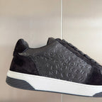Black Chanel low-top sneaker close-up, textured logo pattern and white rubber sole
