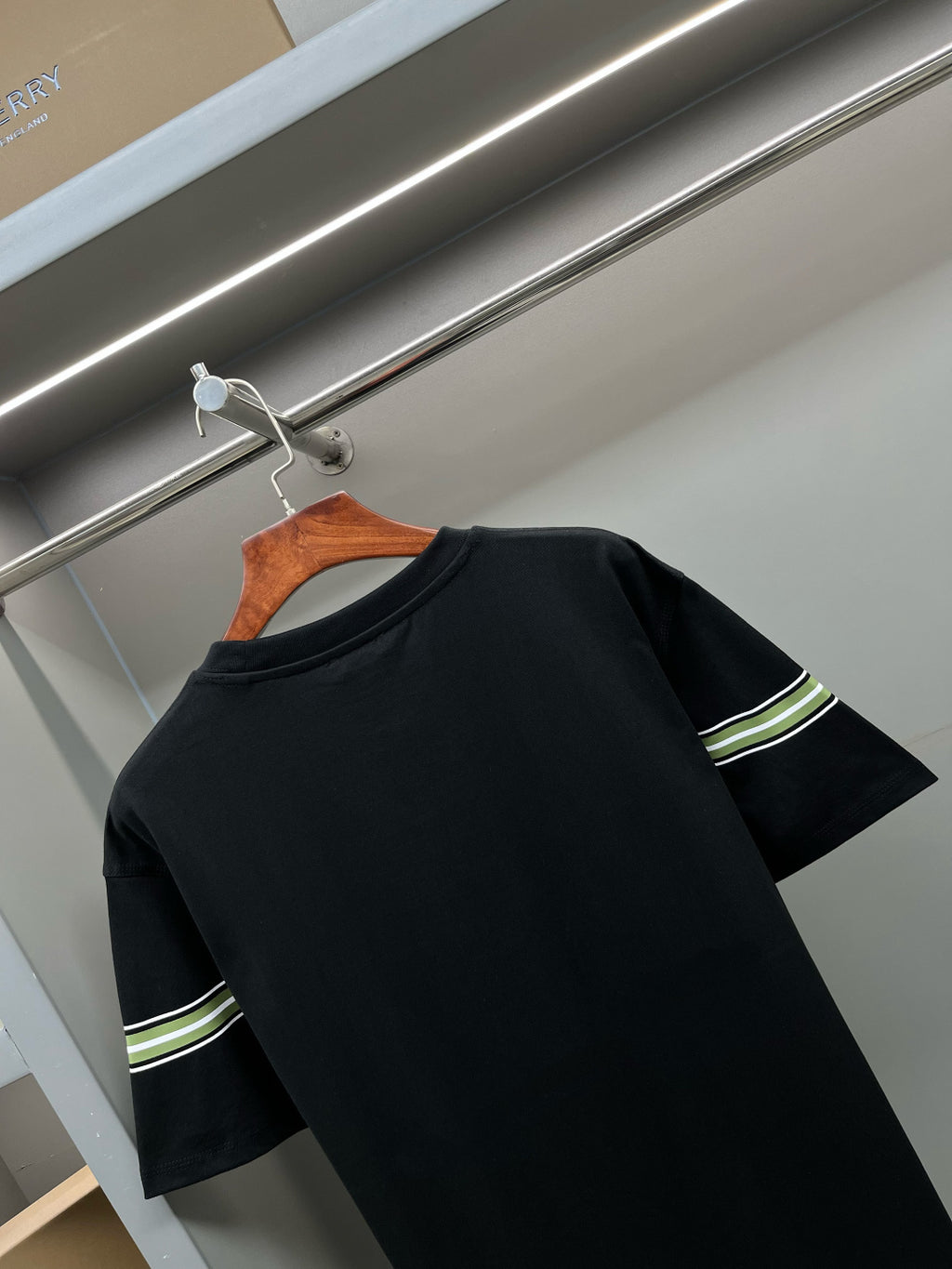 Black short-sleeve T-shirt with green-and-white stripe band on sleeve and upper side