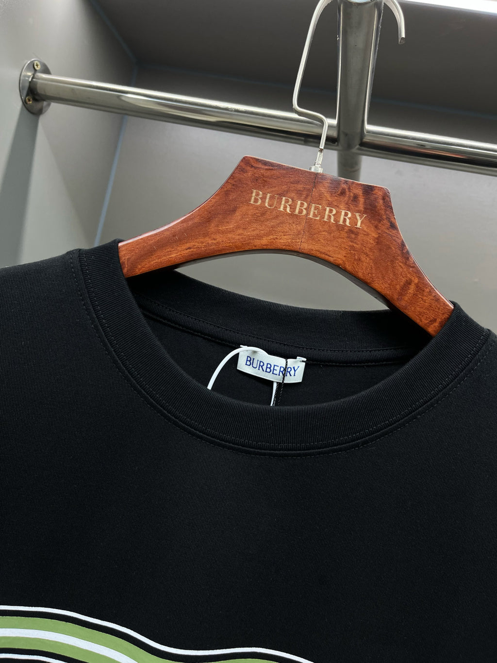 Black crew-neck T-shirt with Burberry label at collar and green-white stripe trim