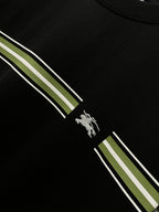 Black T-shirt detail with green-and-white diagonal stripe and horse rider emblem