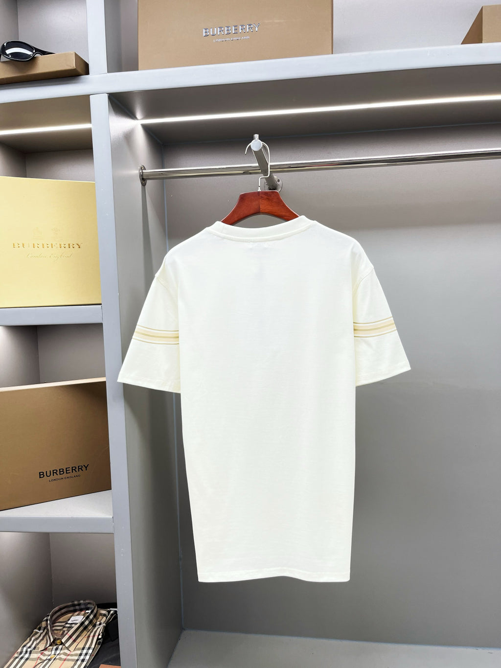 White Burberry T-shirt back view with gold stripe band at sleeve ends, on hanger