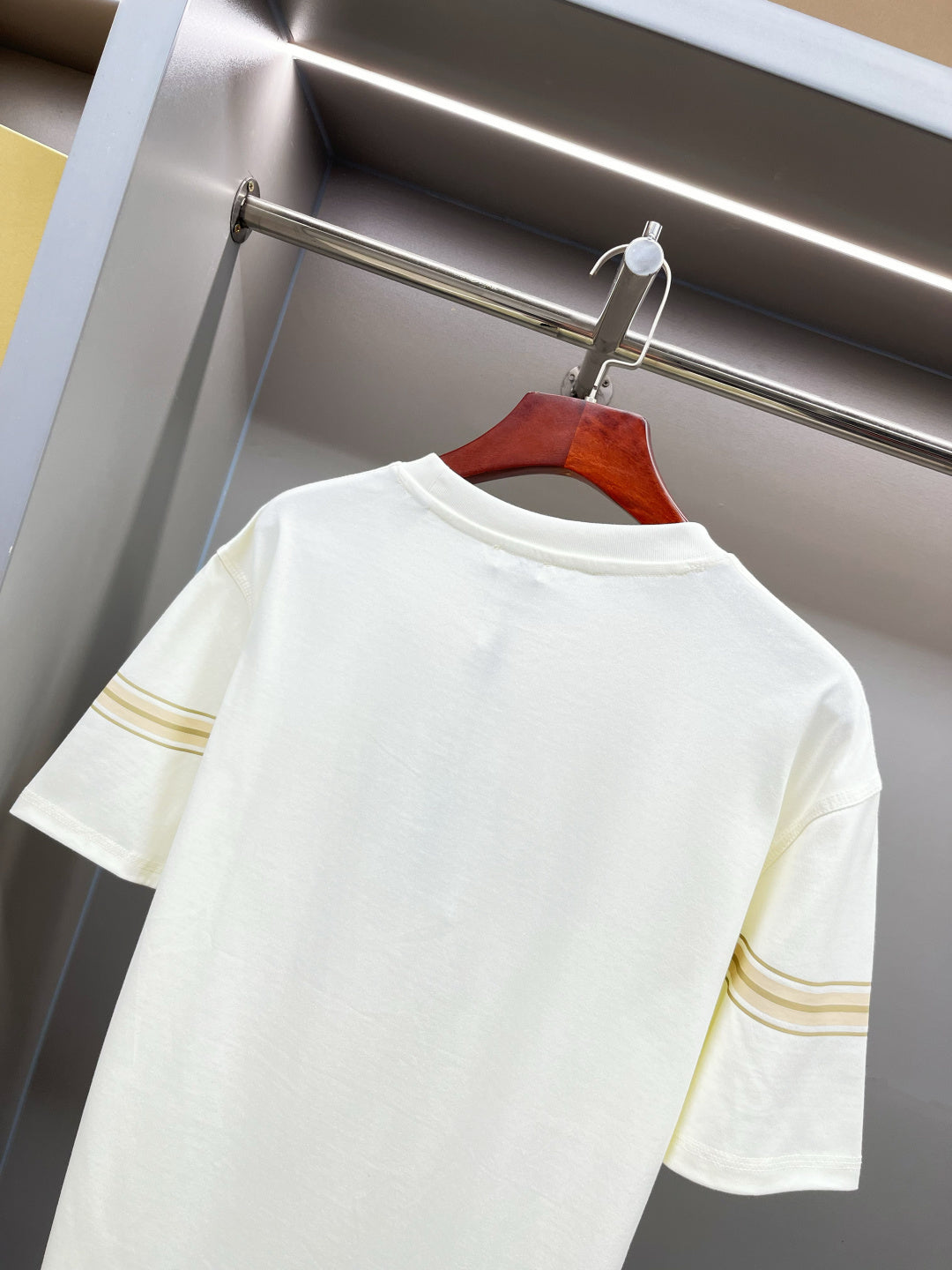 White Burberry T-shirt close-up of back shoulder area and gold sleeve stripe trim