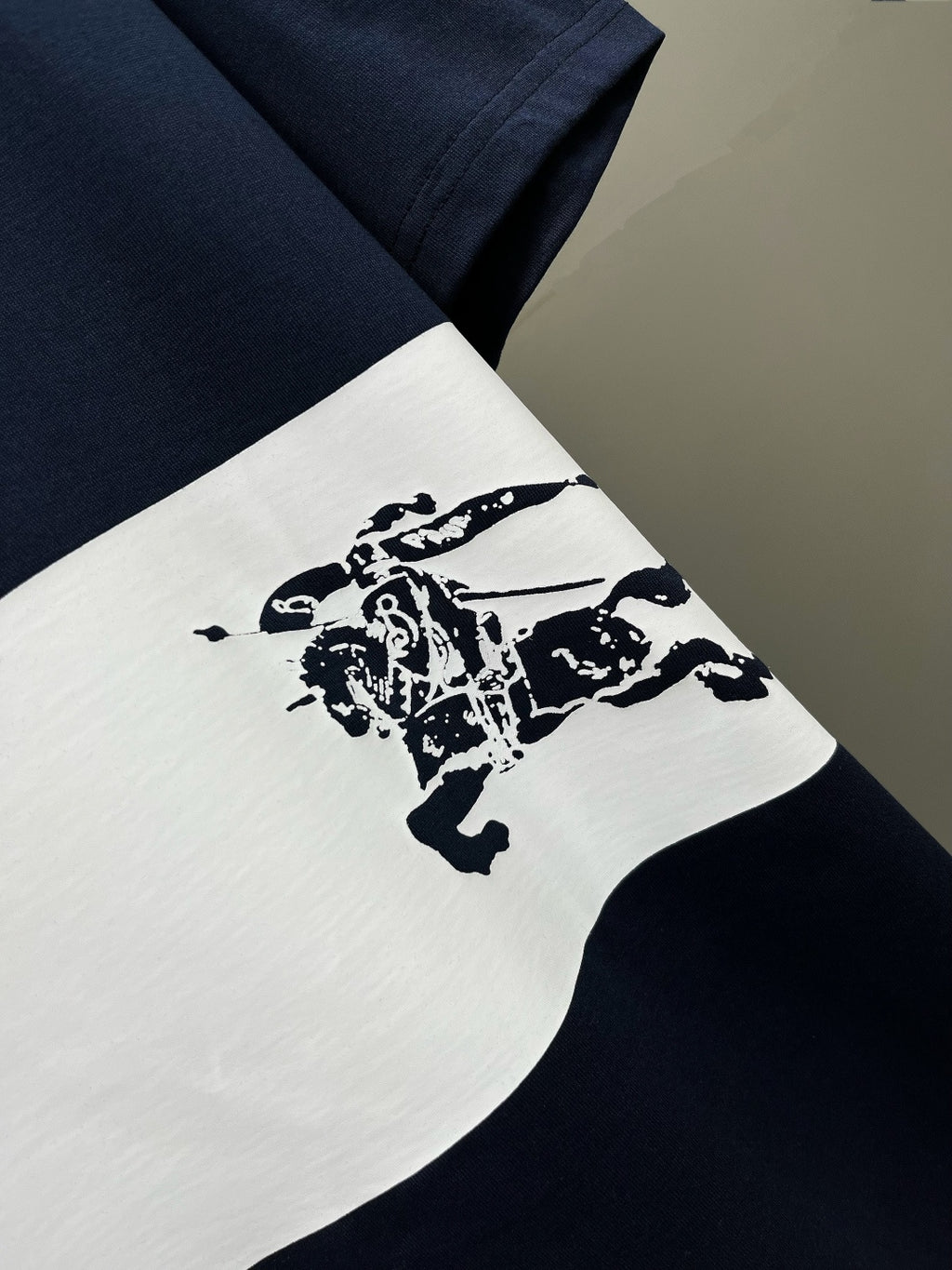Burberry T-shirt sleeve detail with white stripe and navy horse graphic
