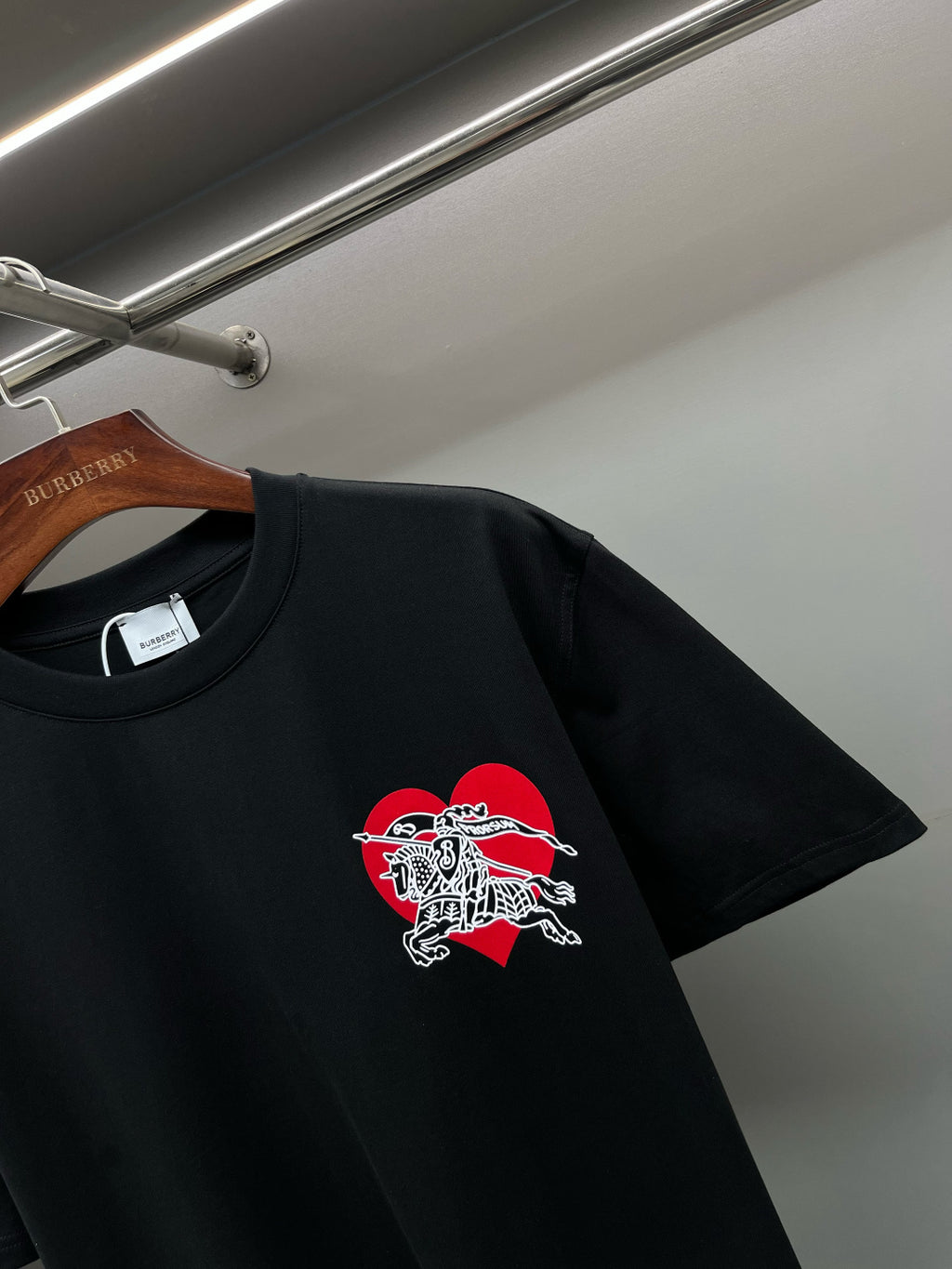 Black short-sleeve T-shirt with red and white horse emblem on chest