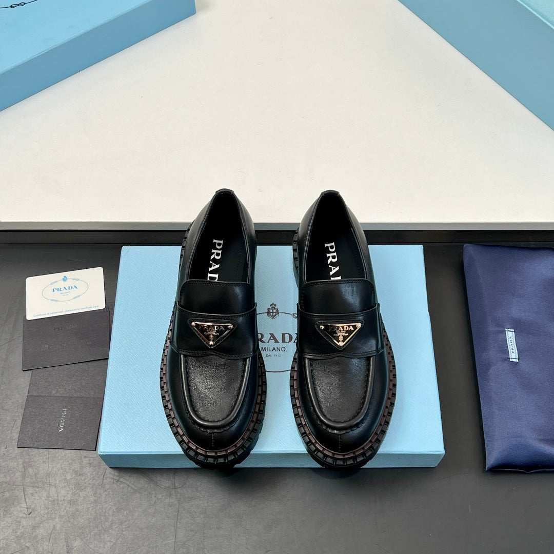 Black Prada unisex loafers, front view on box with logo straps