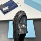 Black leather Prada unisex loafer, side view with triangular logo strap