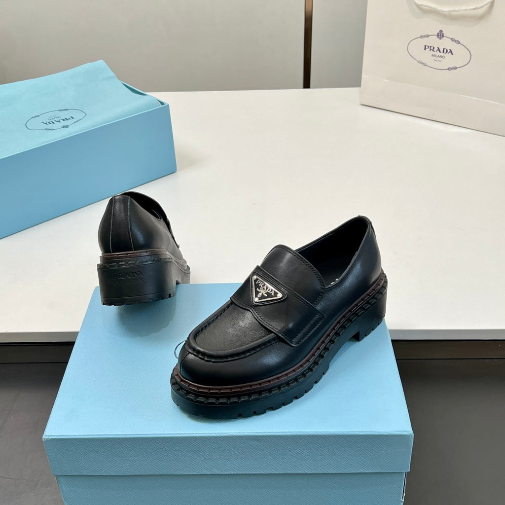Black Prada unisex loafers, heel and side view with strap and logo patch