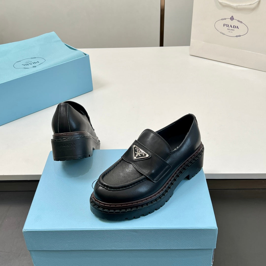 Black Prada unisex loafers, heel and side view with strap and logo patch
