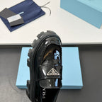 Black patent loafer close-up with strap buckle and chunky lug platform sole