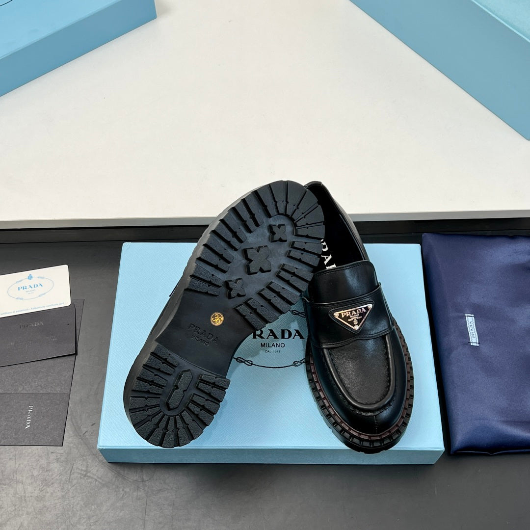 Black Prada unisex loafer soles and side, thick tread with logo