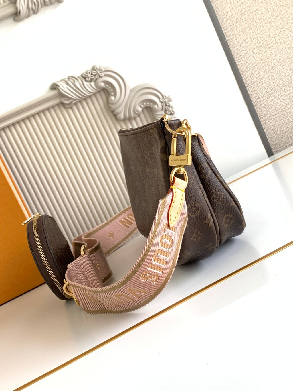 Louis Vuitton crossbody bag in monogram canvas with gold hardware and strap detail