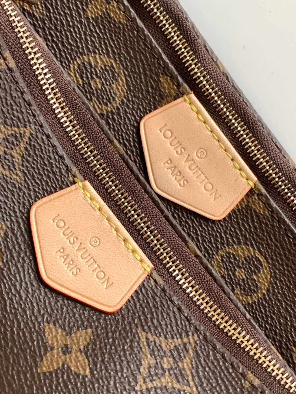 Louis Vuitton monogram bag close-up of zipper and leather logo patch