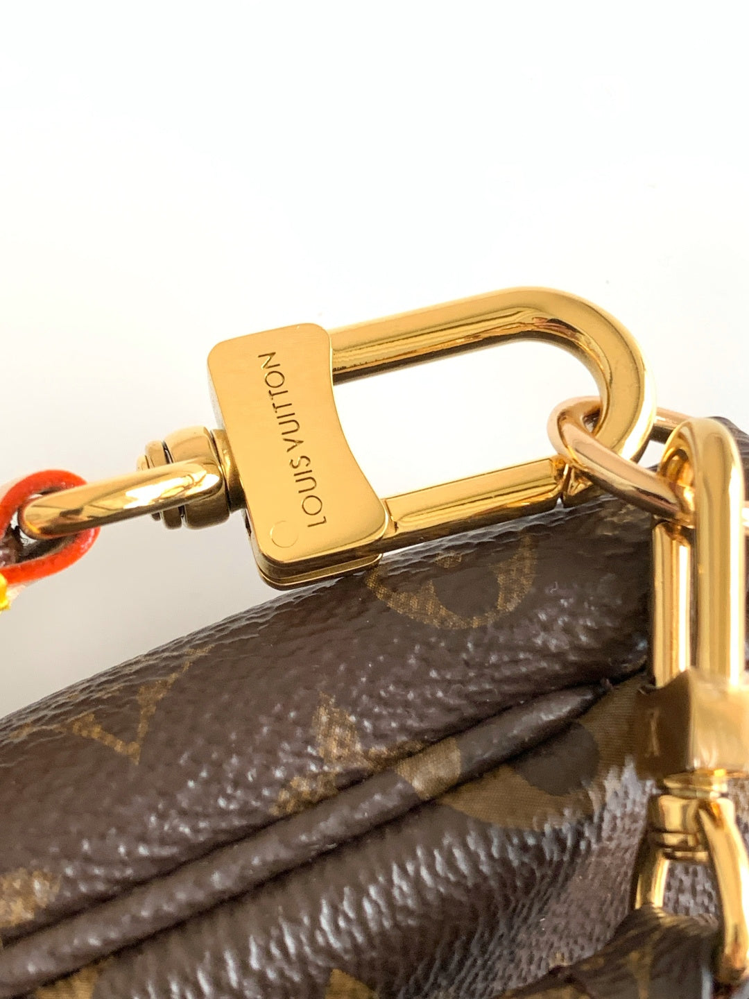 Louis Vuitton bag top handle hardware with gold clasp on brown monogram canvas