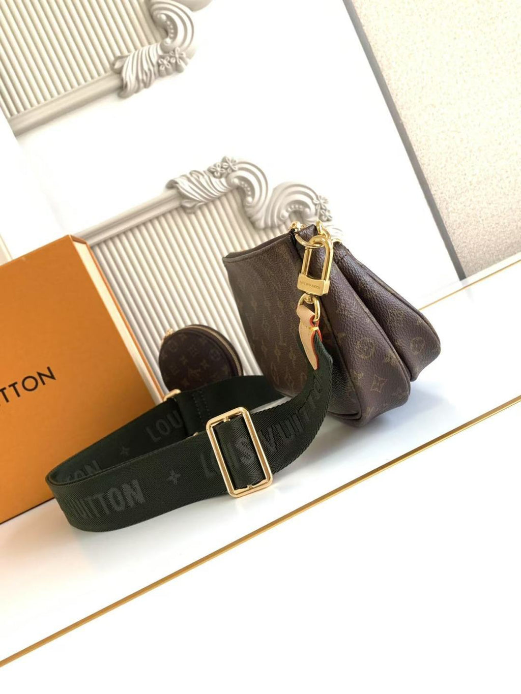 Louis Vuitton monogram shoulder bag with green strap and gold buckle hardware