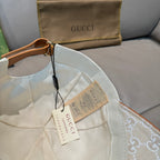 Gucci cap interior with beige GG monogram fabric and tan trim, hanging tags.