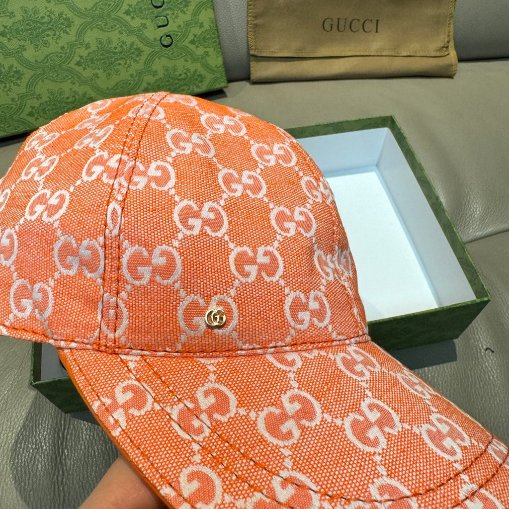 Orange GG monogram baseball cap close-up with textured fabric and contrast stitching