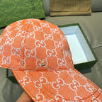 Orange GG monogram baseball cap close-up with textured fabric and contrast stitching
