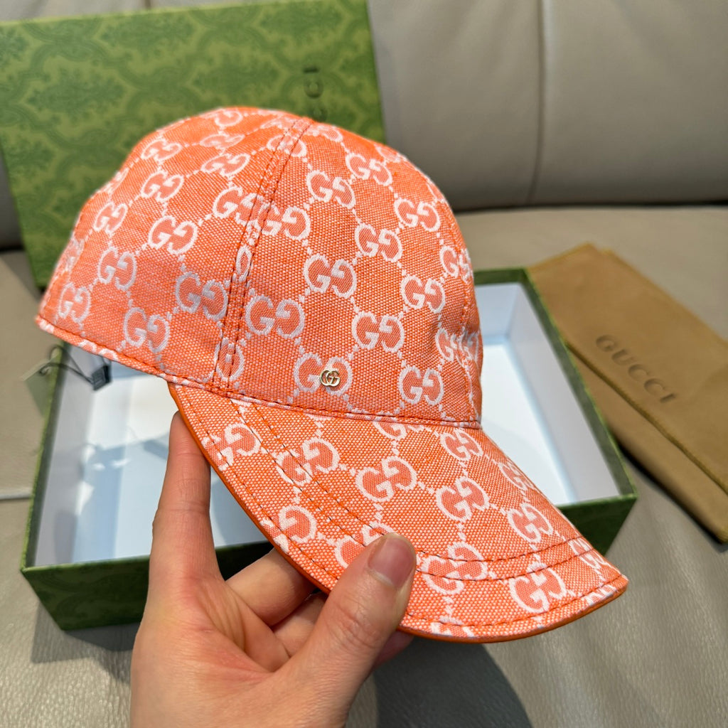 Orange GG monogram baseball cap shown in hand, curved brim and seam lines
