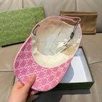Pink GG-print cap interior with beige lining and adjustable chin strap.