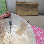 Pink GG-print cap interior with white lining and Gucci hang tags.