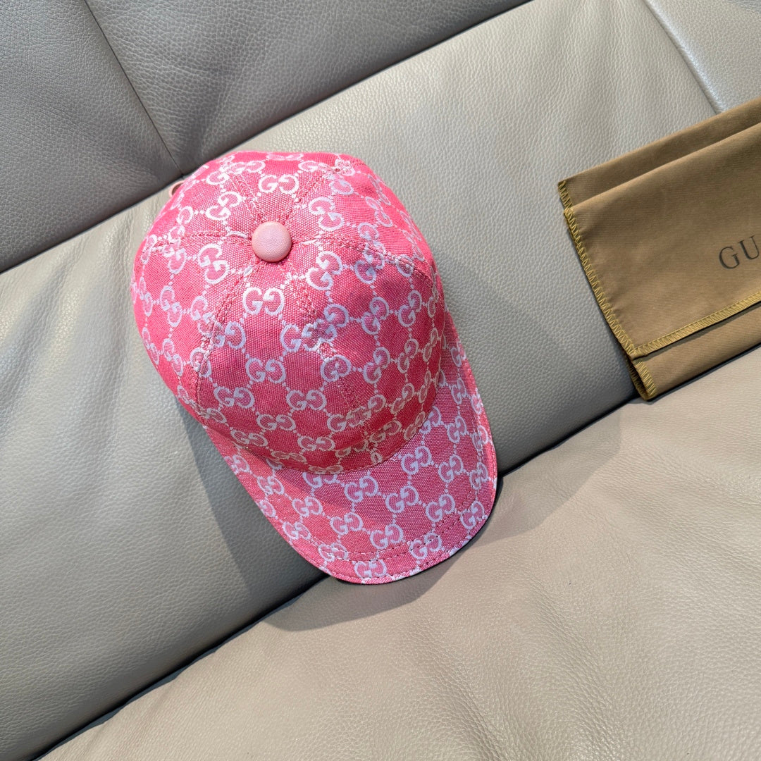 Pink GG-print baseball cap with round top button and short brim.