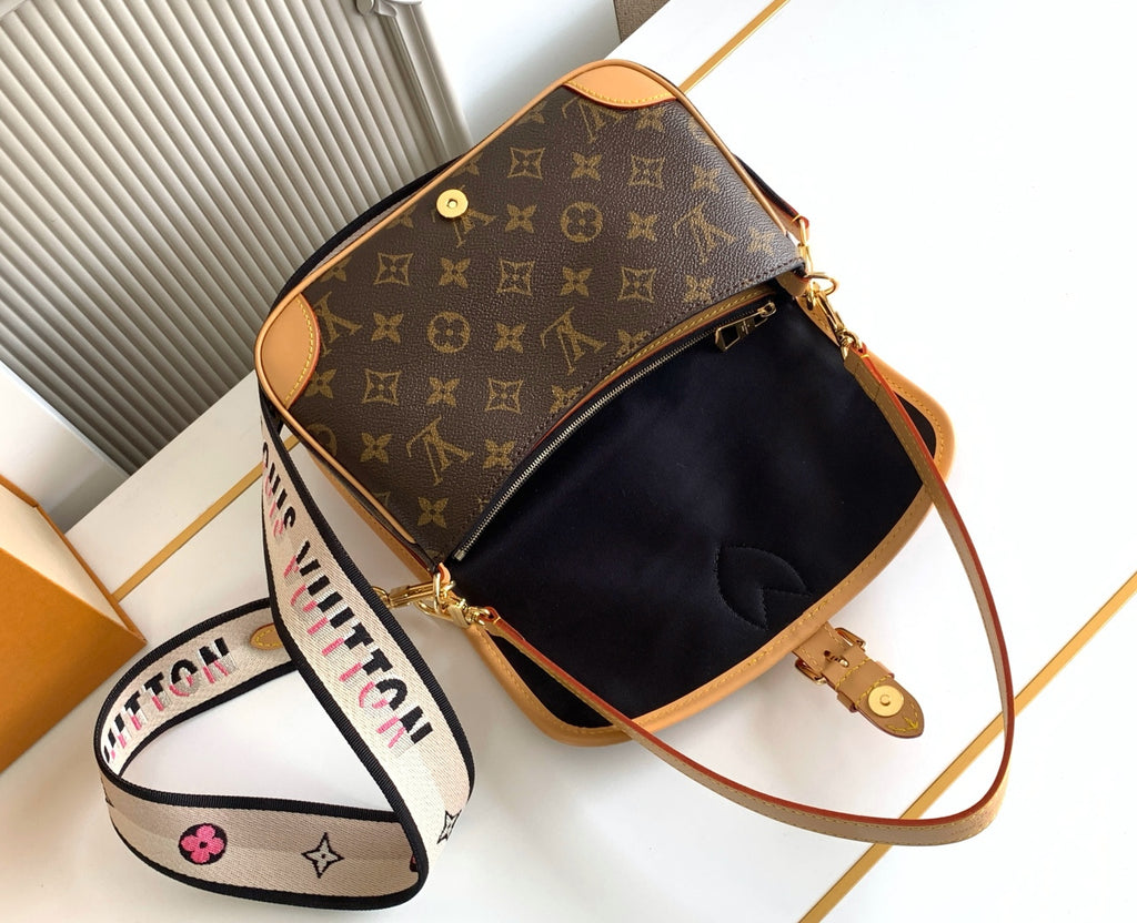 Monogram canvas crossbody bag with open top, black interior, and gold zipper hardware