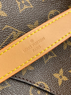 Tan leather strap detail with embossed text and yellow edge stitching
