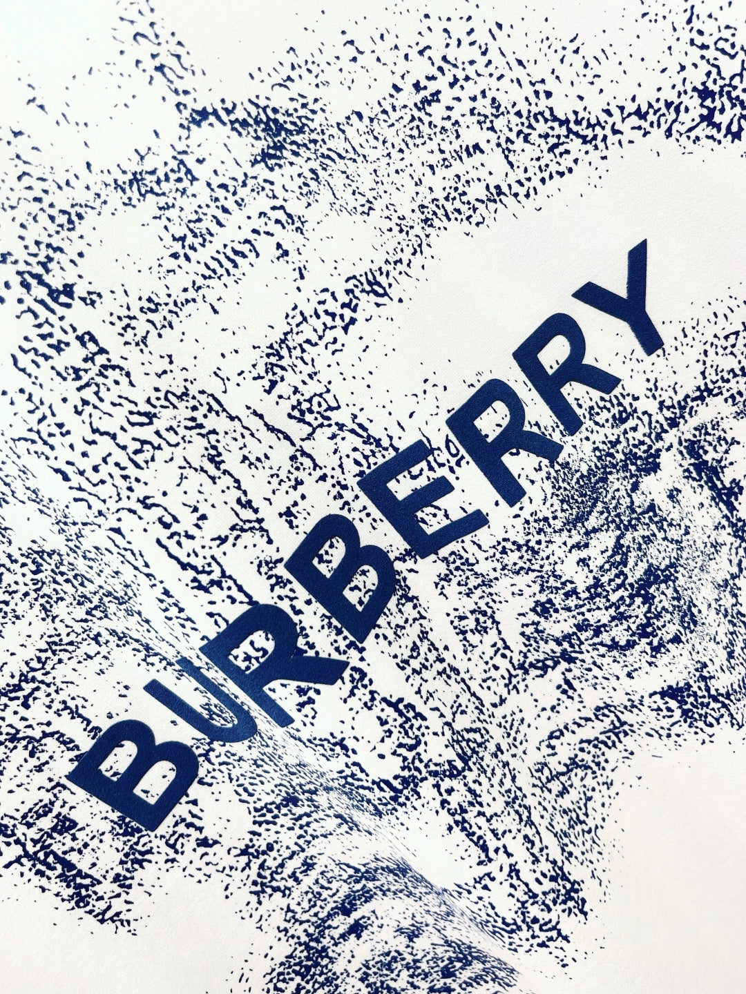 White T-shirt close-up of blue Burberry logo text splash print