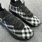 Black and white plaid knit sneakers with braided laces and blue sole trim