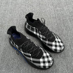 Check knit sneakers in black and white plaid with lace-up front and blue accent