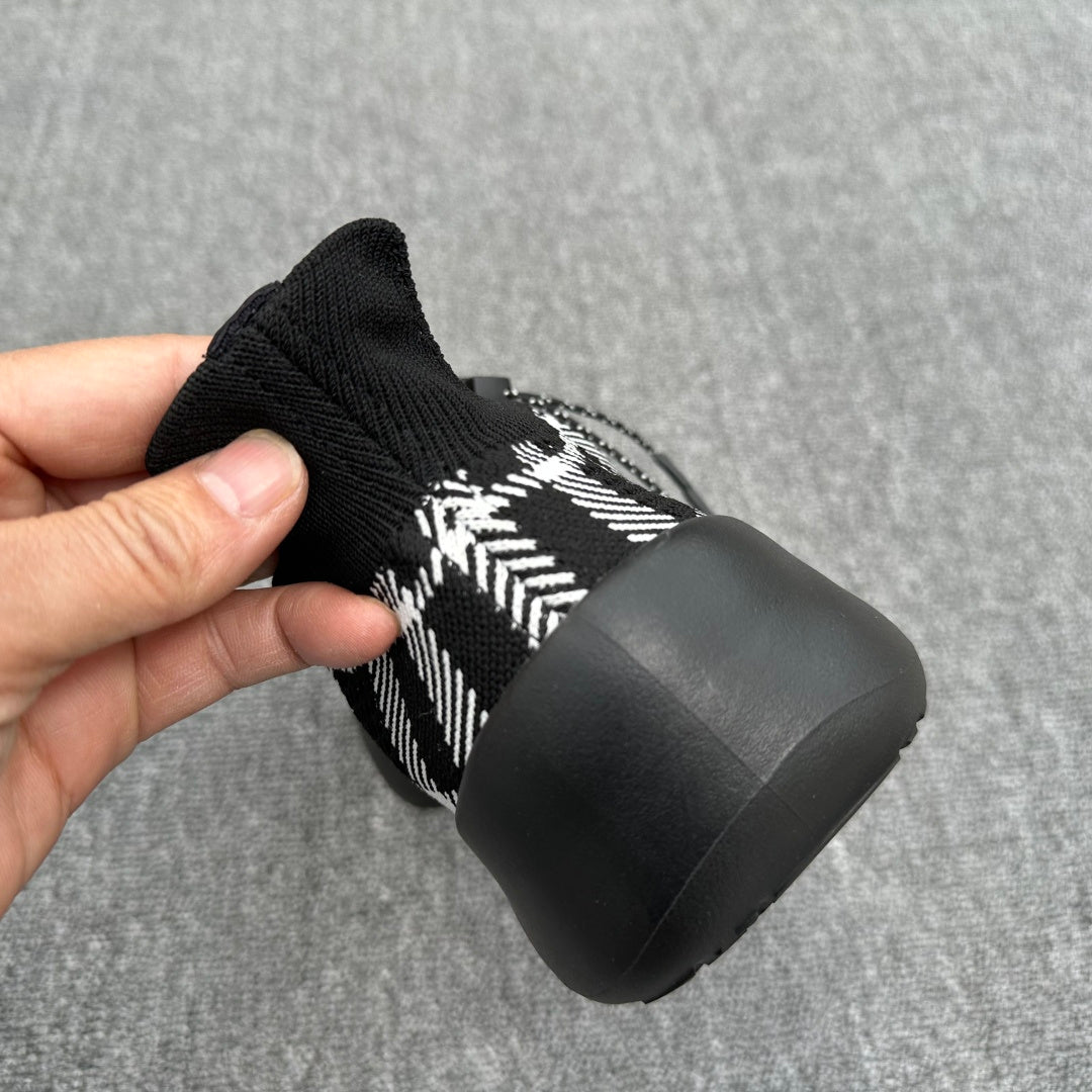 Black and white check knit sneaker heel view with cushioned black rubber outsole
