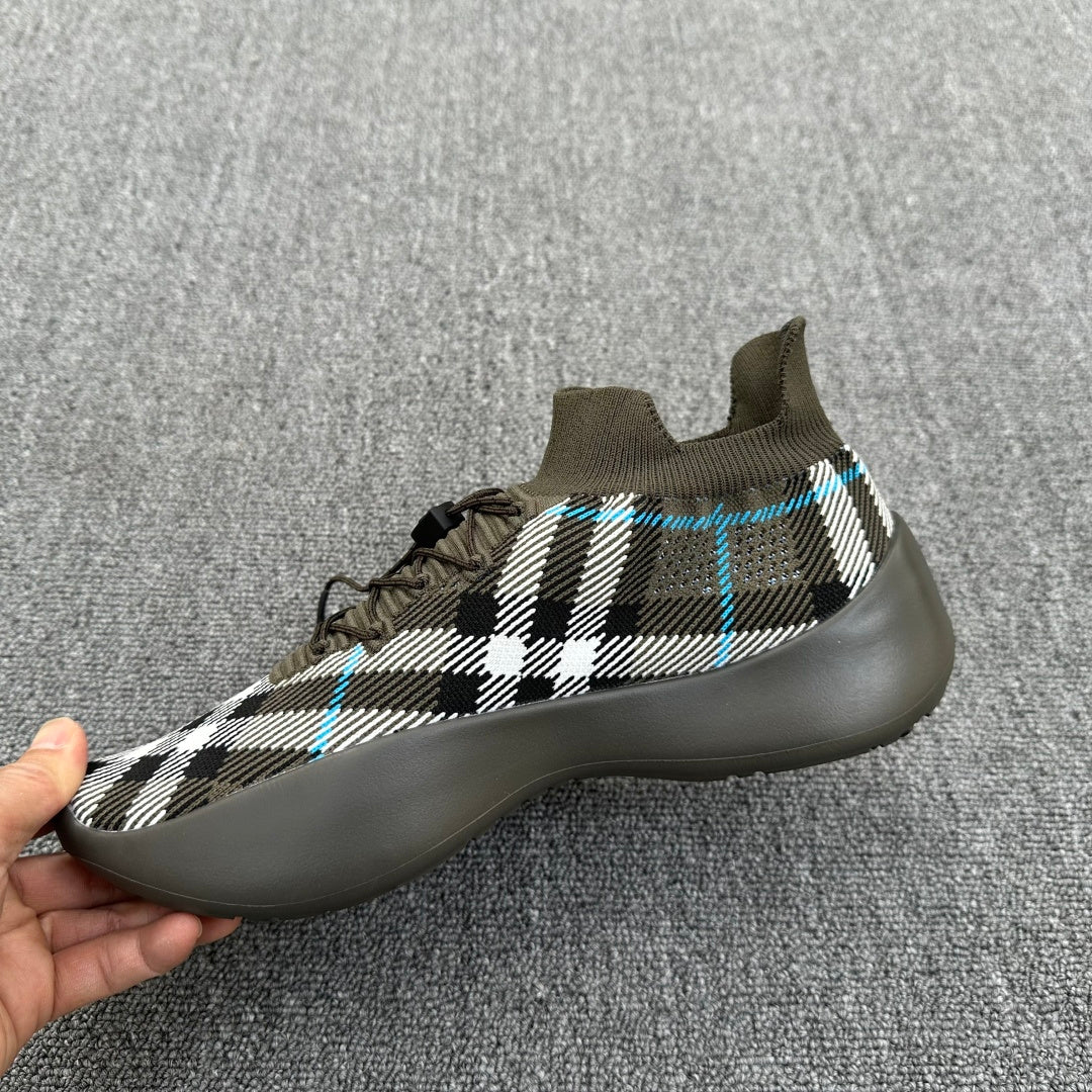 Side view sneaker in olive with black-and-white plaid upper and blue accent lines