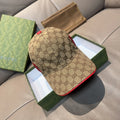 Gucci baseball cap in brown canvas with GG monogram pattern and red contrast trim.