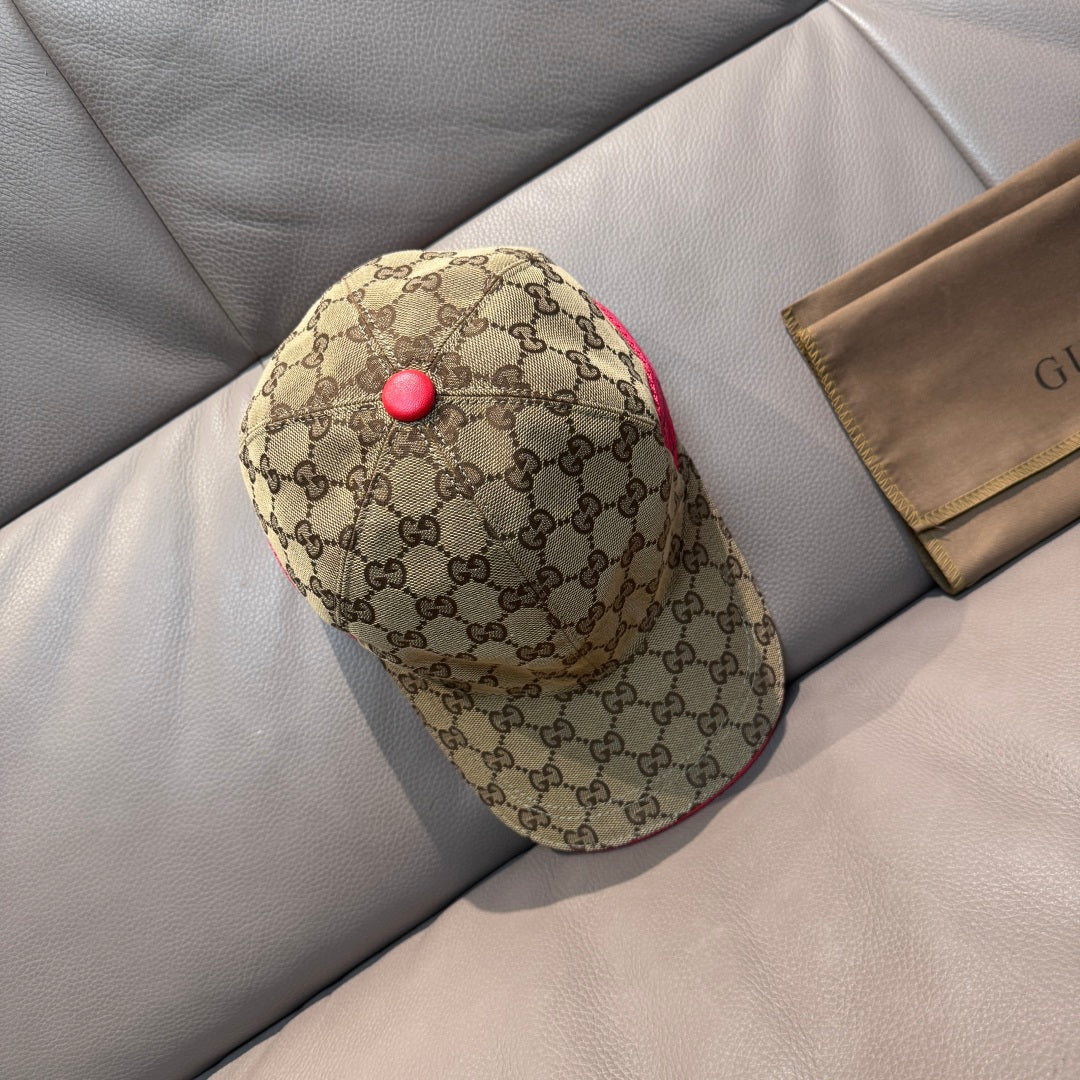 Gucci baseball cap with tan GG monogram print, red button detail, and red piping.