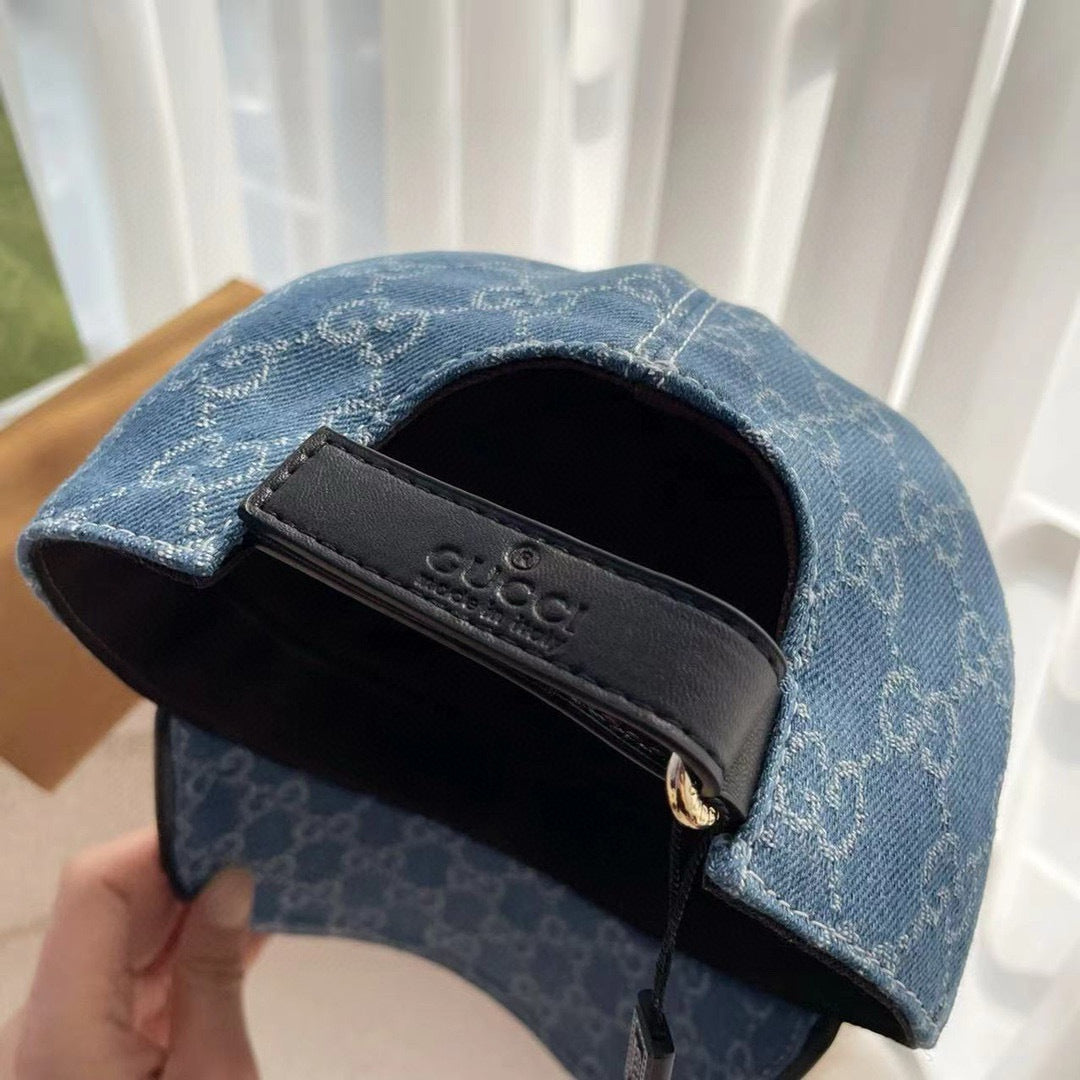 Blue monogram cap with black adjustable buckle strap inside opening.