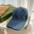 Blue denim-style Gucci monogram baseball cap with green-red web stripe detail.