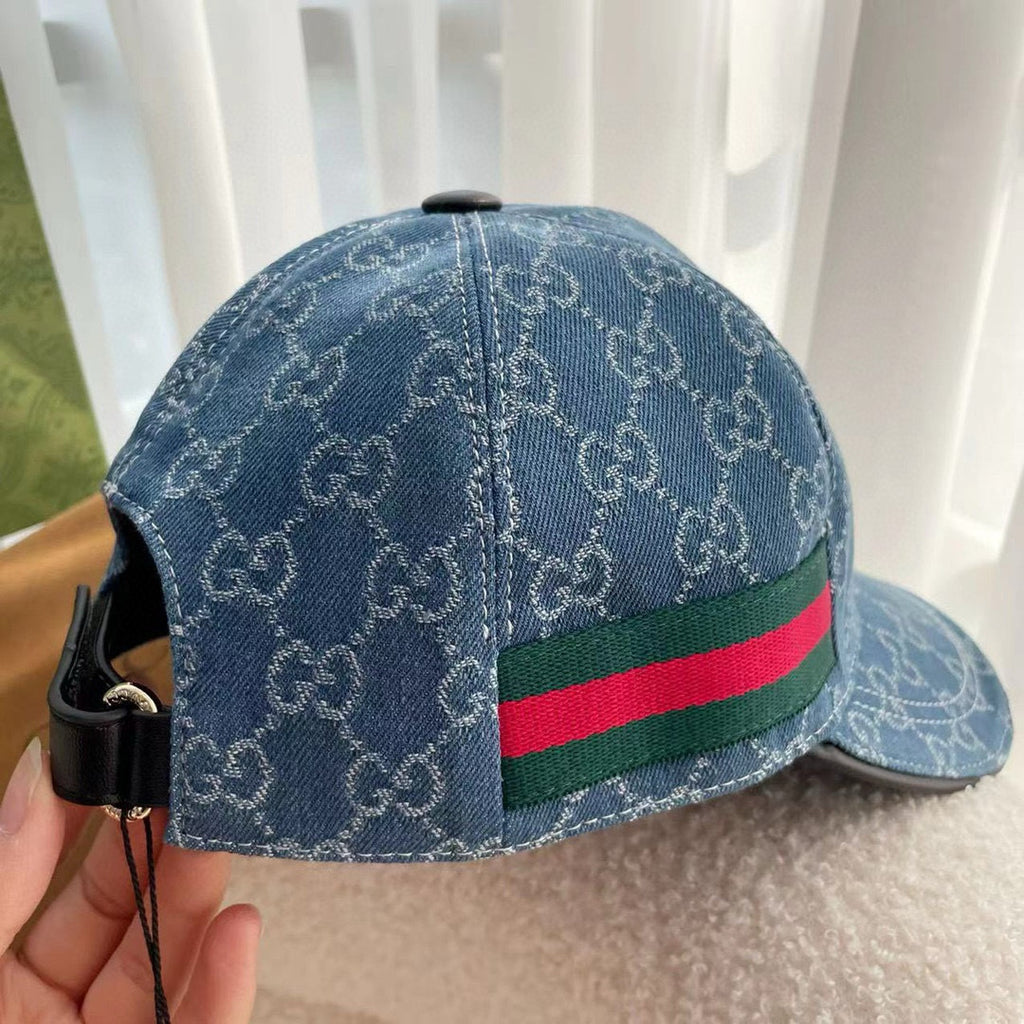 Blue monogram cap showing back seam and green-red web stripe on the band.