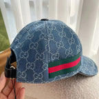 Blue monogram cap showing back seam and green-red web stripe on the band.