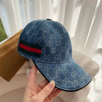 Blue monogram baseball cap side view with green and red web stripe at the band.