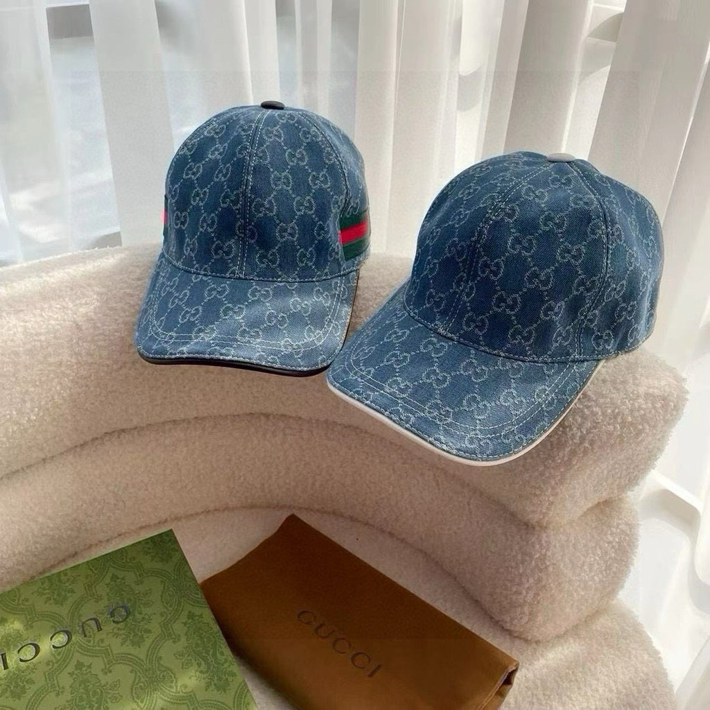 Pair of blue Gucci monogram baseball caps on display