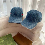 Pair of blue Gucci monogram baseball caps on display