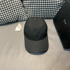 Black Dior cap with button-top crown and curved brim, no logo visible